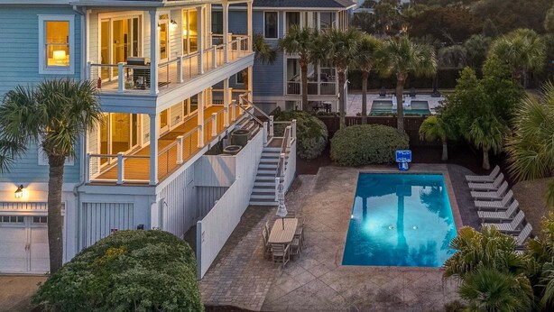 A two-story house with a pool, outdoor seating, and a staircase leading to the upper floor. - Ask for Discounts!! Palm Manor by Exclusive Properties  Pool, Elevator, Views (Isle of Palms)