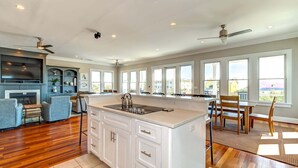A spacious kitchen with a large island, white cabinetry, and a dining area with chairs and a table. - Ask for Discounts!! Palm Manor by Exclusive Properties  Pool, Elevator, Views (Isle of Palms)