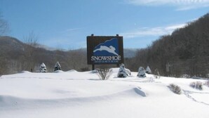 Een besneeerd landschap met een bordje voor Snowshoe Mountain.