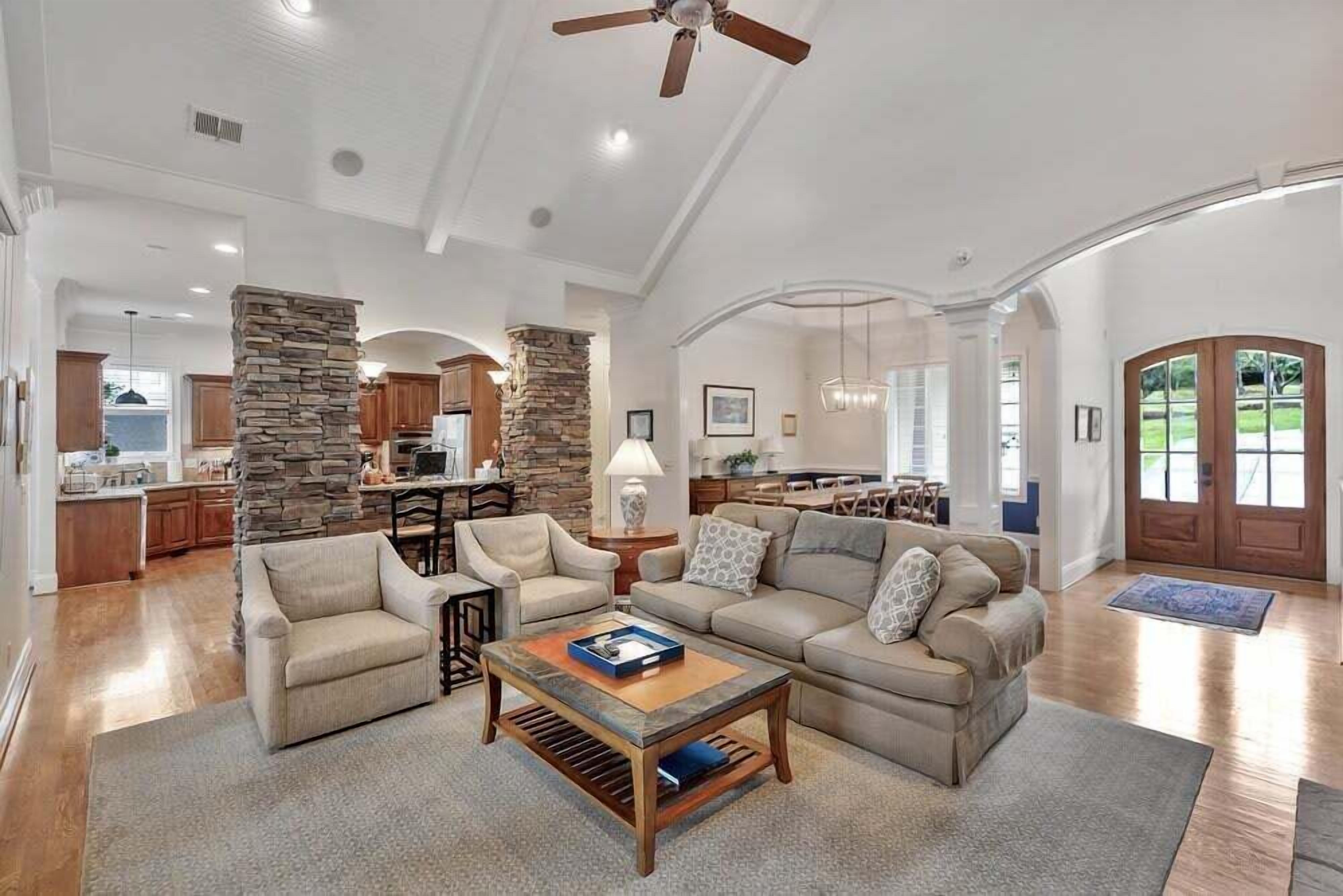 A spacious living room with a stone fireplace, a large sofa set, and a coffee table.