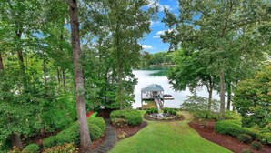 A lakeside property with a well-maintained lawn, a dock, and a gazebo.