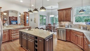 A modern kitchen with granite countertops, wooden cabinets, and stainless steel appliances.