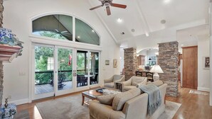 A spacious living room with a large couch, a fireplace, and a stone pillar.