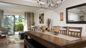 Ein Essbereich mit einem Holztisch, Stühlen und einer Bank. Über dem Tisch hängt eine Chandelier, und an der Wand befindet sich ein großer Spiegel.