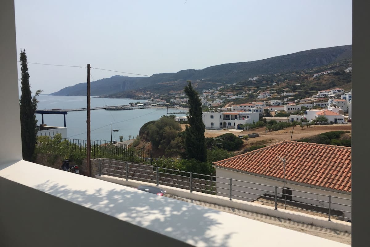 A coastal town with white buildings, a clear sky, and a view of the sea.