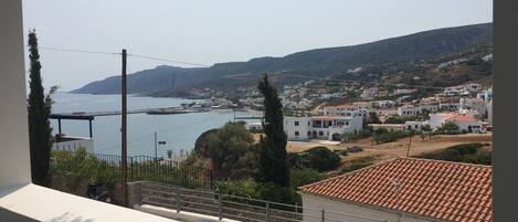A coastal town with white buildings, a clear sky, and a view of the sea.
