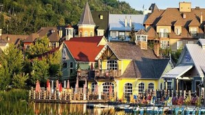 A waterfront hotel with multiple buildings, a dock, and a small boat.