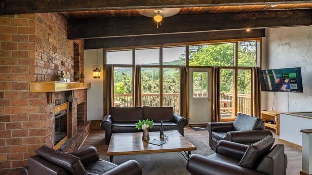 A cozy lounge area with leather sofas, a coffee table, and a fireplace.
