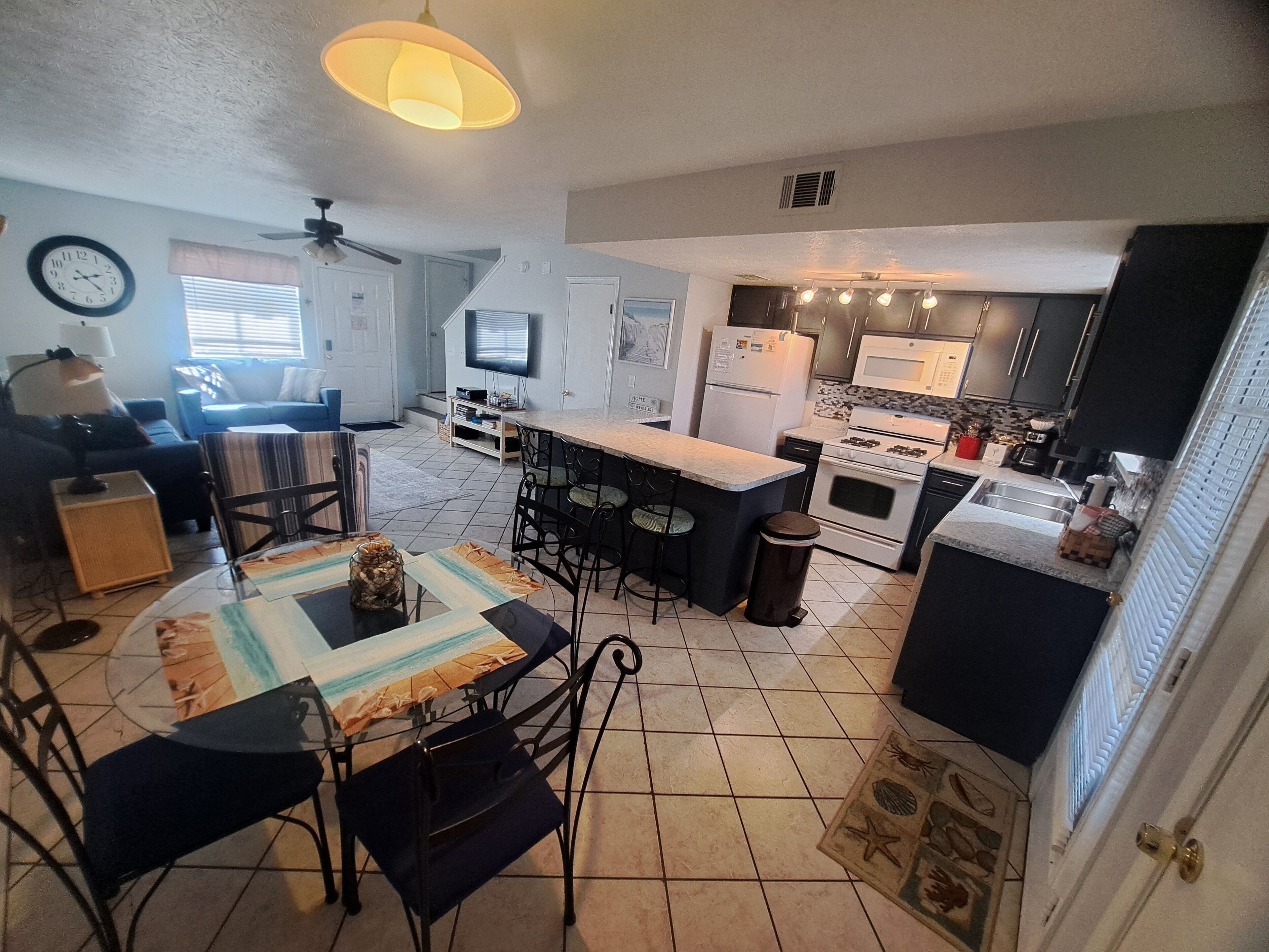 A compact living space with a dining area, kitchen, and a living room.