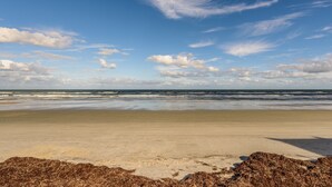A beach with a clear sky and waves.