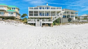 A beachfront property with a multi-level structure, including a main building and an adjacent smaller building.