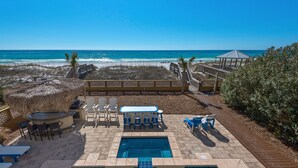 Poolbereich mit Blick auf Strand und Meer, inklusive Liegestühle, Whirlpool und Kiosk.