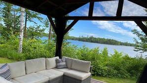 Un espacio de descanso al aire libre cubierto con vista a un lago.