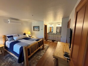 A bedroom with a bed, bedside table, lamp, and a painting on the wall. - Remodel Oct 2026 - Deer Valley Townhouse, with Hot Tub & Steps Away from the Bus (Park City)