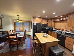 A modern kitchen with wooden cabinets, a black refrigerator, a microwave, and a sink. - Remodel Oct 2026 - Deer Valley Townhouse, with Hot Tub & Steps Away from the Bus (Park City)
