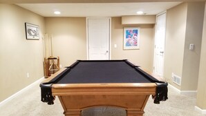 A pool table in a room with beige walls, a white door, and a framed picture on the wall. - Richfield Charmer - Free WiFi and Close to MSP & Mall of America (Minneapolis)