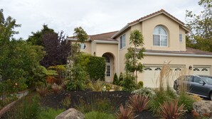 A two-story house with a beige exterior, a tiled roof, and a garage. - Executive Vacation House Next to Ritz-Carlton in Half Moon Bay (Half Moon Bay)