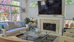A modern living room with a large flat-screen TV, a fireplace, and comfortable seating. - Executive Vacation House Next to Ritz-Carlton in Half Moon Bay (Half Moon Bay)