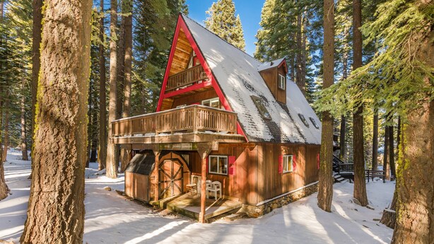 Een chalet met een houten gevel, een balkon en een grote voordeur.
