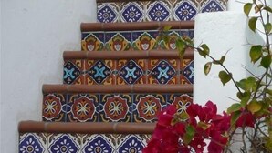 A staircase with colorful, patterned tiles and a white wall.