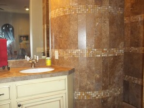 Un bagno con lavandino, specchio e pareti piastrellate.