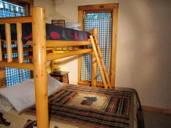 A bunk bed with a checkered curtain and a plaid bedspread. - Fly Fishing River Chalet, Fly Shop, Guides, Schools, & Kayaks! (River Falls)
