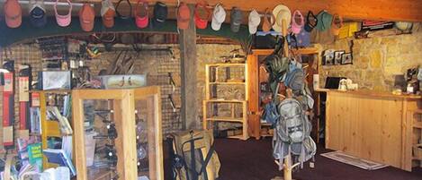 A rustic room with wooden shelves, a hat rack, and various items including books and a backpack.