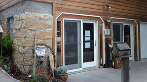 A wooden building with a stone foundation, a large wooden wheel, and a sign warning against drinking water. - Fly Fishing River Chalet, Fly Shop, Guides, Schools, & Kayaks! (River Falls)