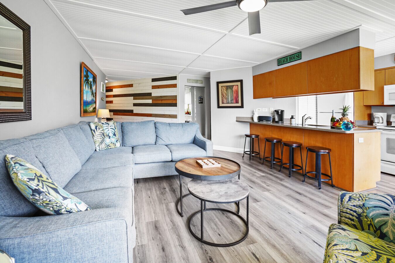 A modern living room with a sectional sofa, a coffee table, and a kitchen area with a bar.