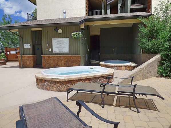 Un espace piscine doté de jacuzzis et de chaises longues.