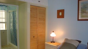 A bedroom with a bed, a nightstand with a lamp, a wooden wardrobe, and a framed picture on the wall. - Feb 3-10
$245 off the rates
close beach full kitchen & patio (Key West)