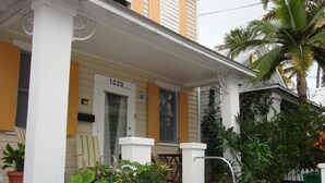 A house with a porch, a door labeled "1020", and a small table and chair set. - Feb 3-10
$245 off the rates
close beach full kitchen & patio (Key West)