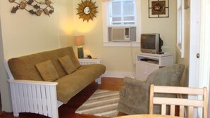 A cozy living room with a sofa, a chair, a table, and a television. - Feb 3-10
$245 off the rates
close beach full kitchen & patio (Key West)