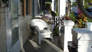 A covered porch with a white chair, a small table, and potted plants. - Feb 3-10
$245 off the rates
close beach full kitchen & patio (Key West)