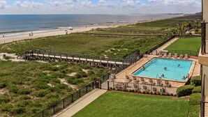 Ein Poolbereich mit Blick auf Strand und Meer.