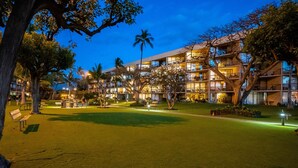 Ein Hotel mit mehreren Etagen, Außenbereich und Palmen.