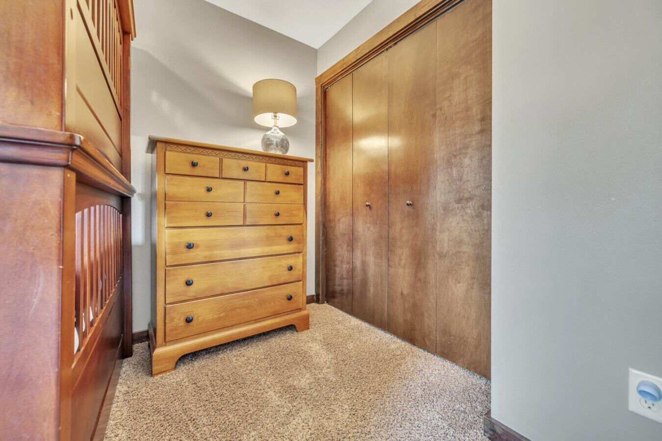Ein Flur mit einem Holzschrank, einer Lampe und einem großen Kleiderschrank.
