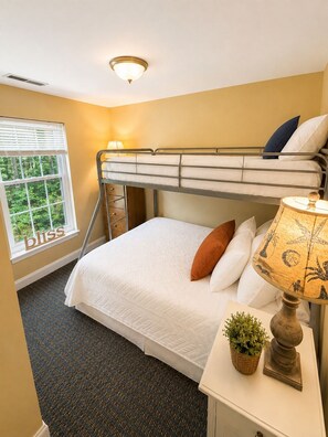 A bunk bed room with a window, a bedside lamp, and a small plant on the nightstand. - Goose Rocks Beach!!  Sunny bright condo. (Kennebunkport)