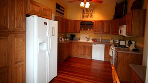 A kitchen with wooden cabinets, a white refrigerator, a dishwasher, and a ceiling fan. - AWESOME STURGIS HOME FOR STURGIS RALLY (Sturgis)