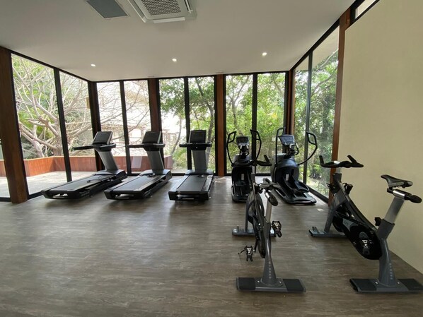 A gym with treadmills, elliptical machines, and stationary bikes.