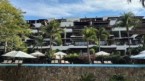 A multi-story hotel with balconies, outdoor seating, and palm trees. - Best Amazing Deal  Beach Front & Stunning Views +Chef & Maid included (Punta de Mita)