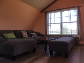 Living room has an enormous, comfy, brand new sectional sofa 