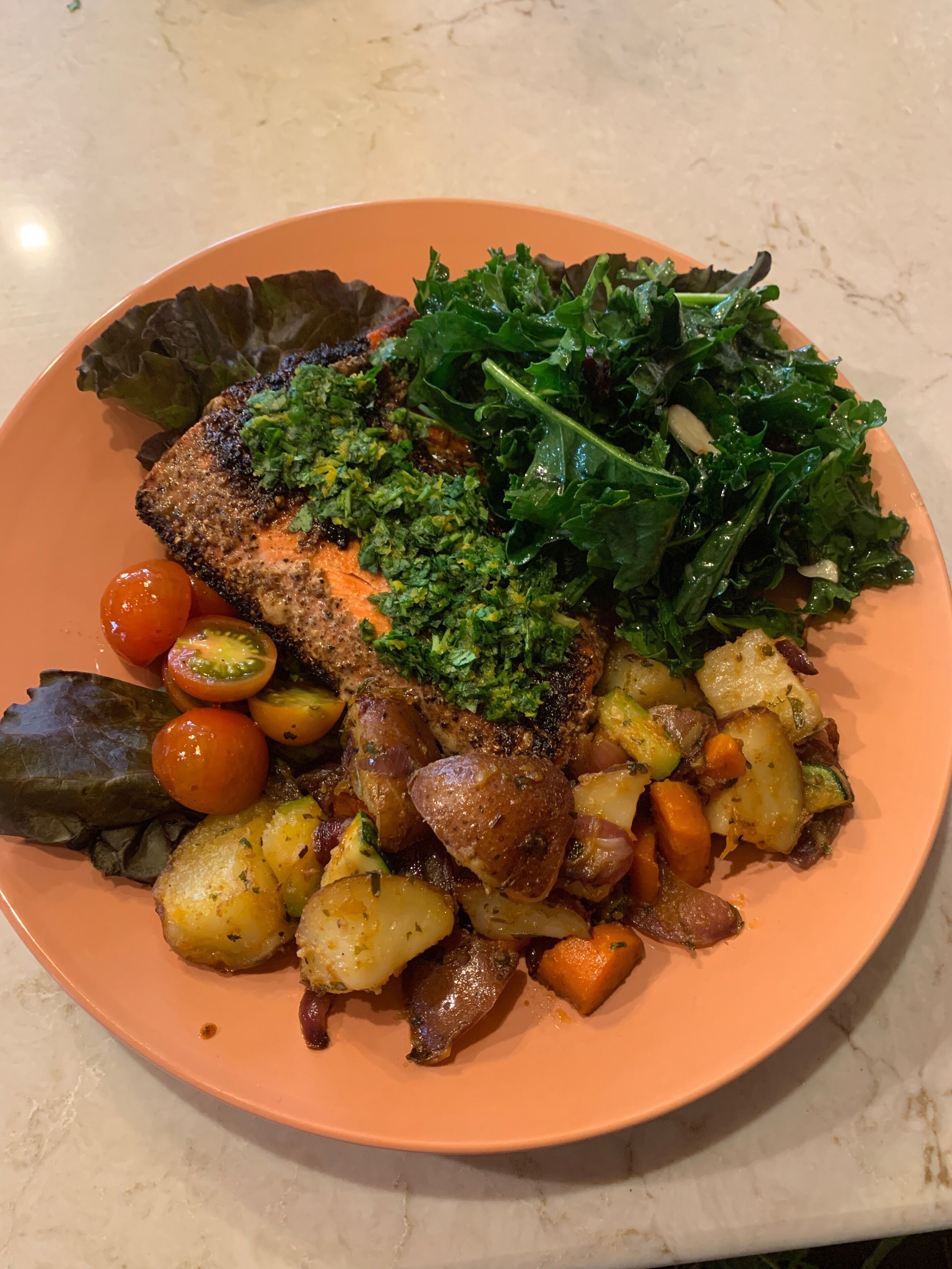 Een bord met gegrilde zalm, groentemix en salade.