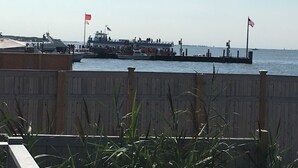 Un moll amb un vaixell amarrat, una bandera i una vista de l'aigua.