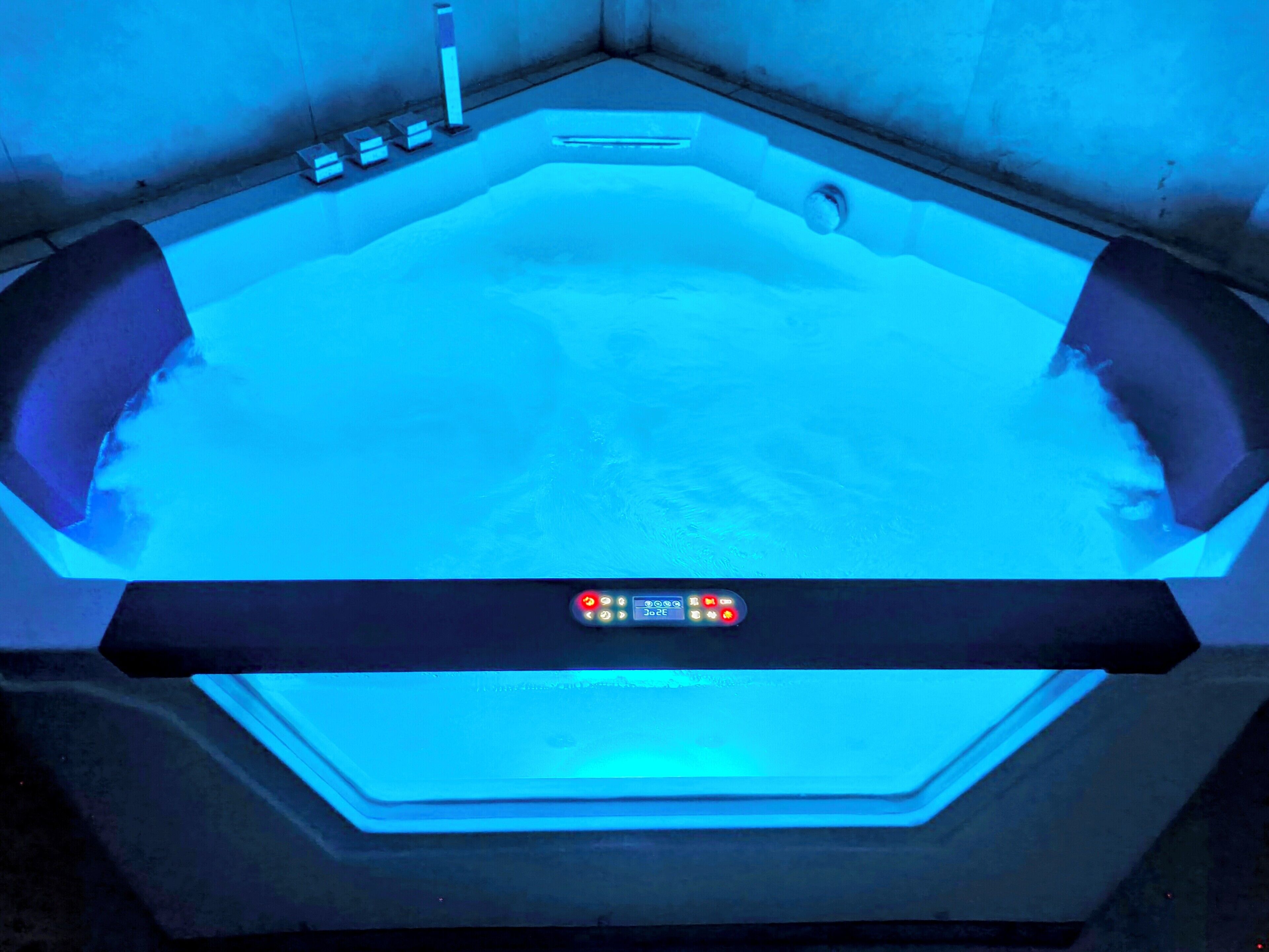 A hot tub with a control panel and a view of the surrounding area.