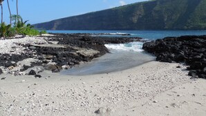 Una playa con terreno rocoso y una vista despejada del océano.