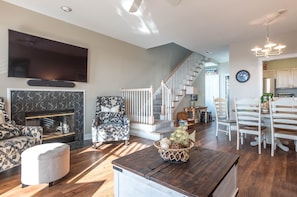 Cozy living space with a fireplace, flat-screen TV, and dining area.