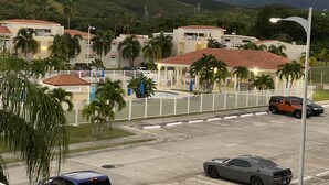 Un complejo turístico con varias edificaciones, piscina y palmeras.
