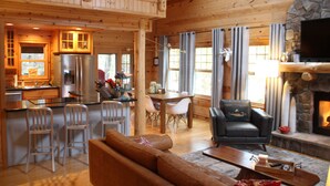 Un interior de cabaña espacioso con comedor, cocina y sala de estar.