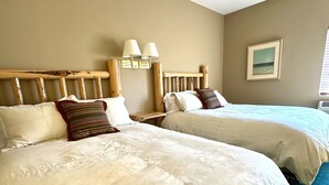 Two beds with headboards, a nightstand, a lamp, and a framed picture on the wall. - Looking for an Alternative to a Big Box Motel?  We're it! (Gardiner)